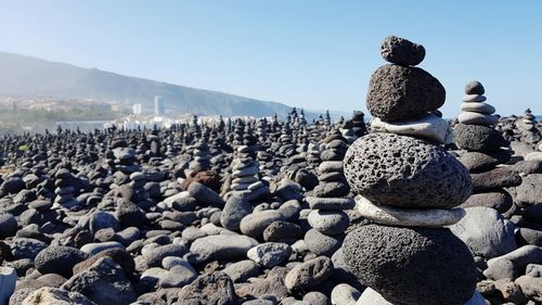 Stack of stones on shore against sky