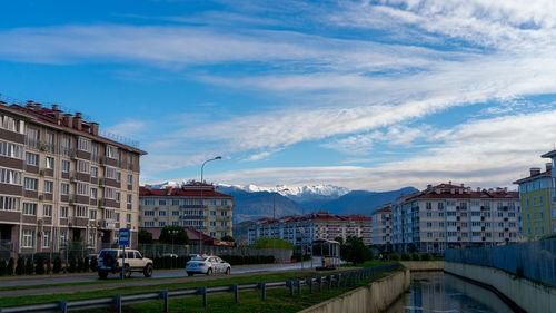 Buildings in city against cloudy sky