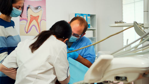 Dentists treating girl at clinic