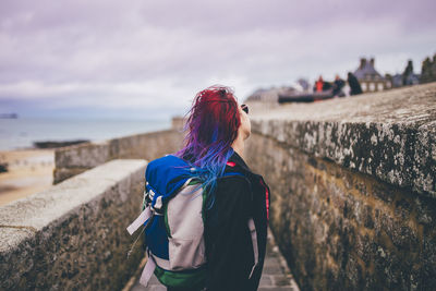 Rear view of woman standing against wall