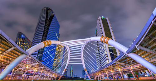 Low angle view of illuminated bridge in city at night