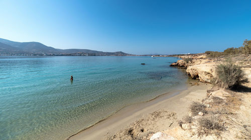 Scenic view of beach against clear blue sky