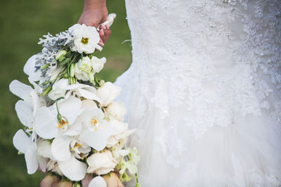 Close-up of bride holding white flowers