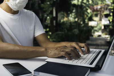 Midsection of man using laptop on table