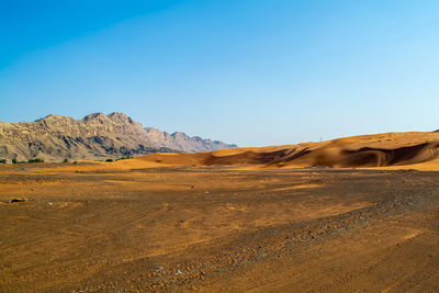 Scenic view of desert against clear blue sky