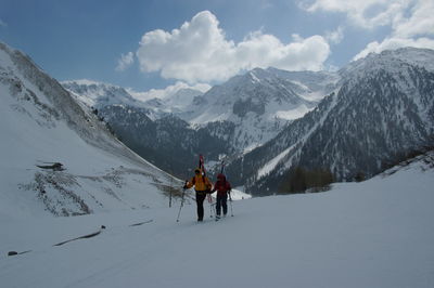 Friends hiking on snowcapped mountain during winter