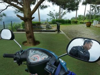 Reflection of man on side-view mirror