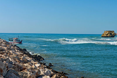 Scenic view of sea against clear blue sky