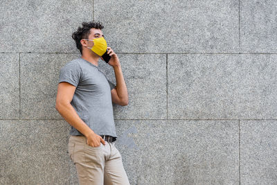 Side view of young man using mobile phone