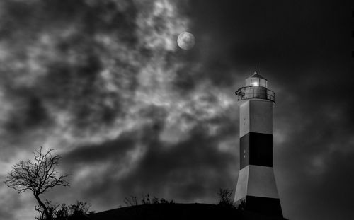 Low angle view of lighthouse and buildings against sky