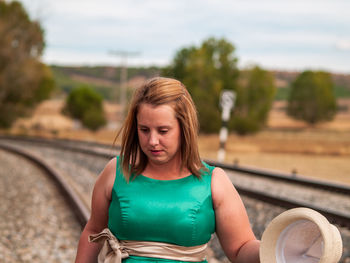 Beautiful overweight woman standing at railroad track