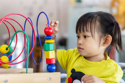 Portrait of cute boy playing with toy on table