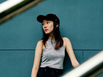 Beautiful fashionable woman standing against wall