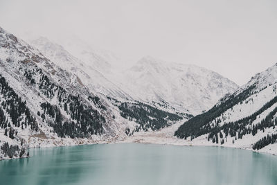 Scenic view of lake and snowcapped mountains against sky