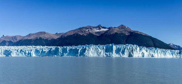 Scenic view of snowcapped mountains against clear blue sky