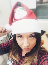 Portrait of a smiling young woman wearing hat at home