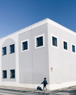 Full length side view of man walking against building