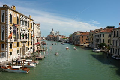 Boats in canal amidst buildings in city