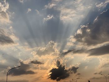 Low angle view of street light against dramatic sky