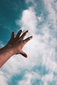 Low angle view of hand against sky