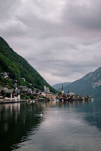 Scenic view of lake by buildings against sky