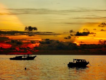 Silhouette boat in sea against sky during sunset