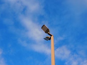 Low angle view of street light against blue sky