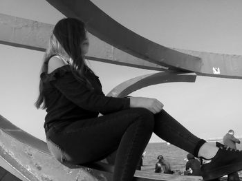 Low angle view of girl playing against clear sky