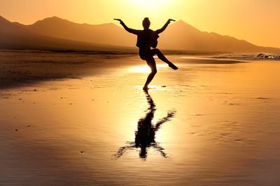 Full length of silhouette person on beach against sky during sunset