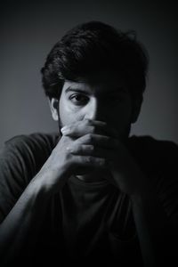 Close-up portrait of young man against black background