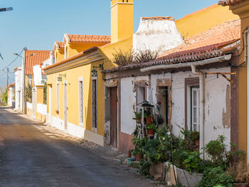 Houses by street in town against sky