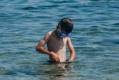 Shirtless boy in sea