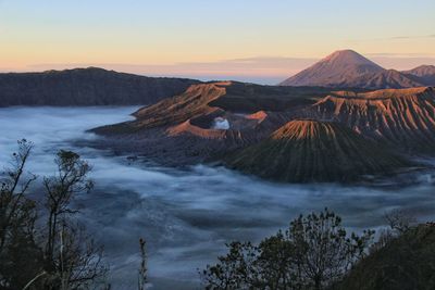 Panoramic view of arid landscape against sky during sunset. mount bromo national park
