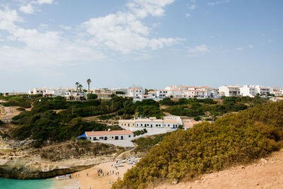 Scenic view of beach by buildings against sky