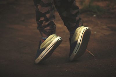 Low section of boy balancing on toes