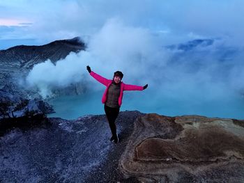 Girl standing on mountain against sky