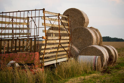 Hay bales on field against sky