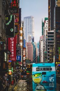 Illuminated city street and buildings against sky