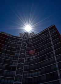 Low angle view of modern building against sky on sunny day