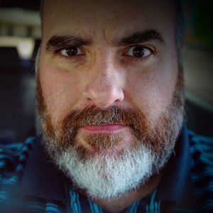 Close-up portrait of serious man with beard in car