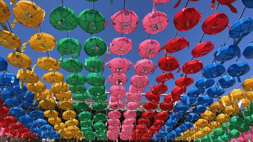 Low angle view of multi colored lanterns hanging against sky