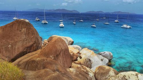 Sailboats moored on sea against sky