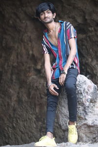 Portrait of young man standing on rock