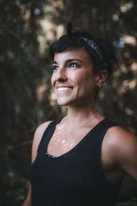 Smiling woman standing in forest