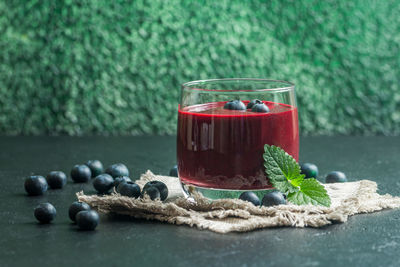 Close-up of fruits with drink on table