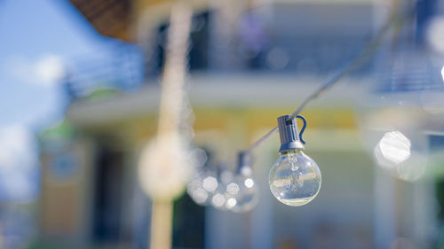 Close-up of light bulb hanging on cable