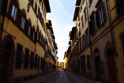 Empty road amidst buildings in city