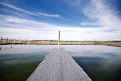 Jetty in lake against sky