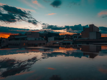 Houses in city against sky during sunset