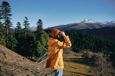 Rear view of woman standing against mountain
